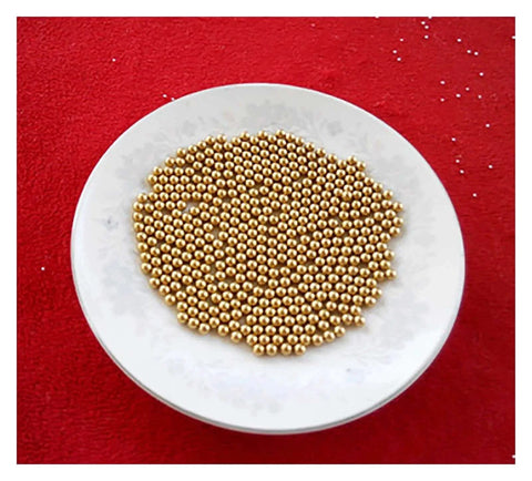 Plate of 100-Pack 3.175mm Ceramic Balls Solid H62 Brass Ball - Precision Smooth Beads Round Balls on red background