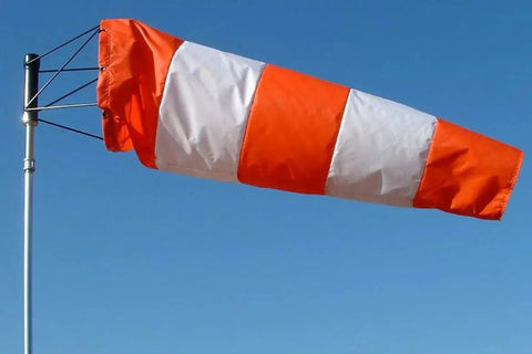 USA Made 18 Inch By 60 Inch Orange And White Nylon Windsock Kit with heavy duty ball bearing frame mounted on a pole against blue sky.