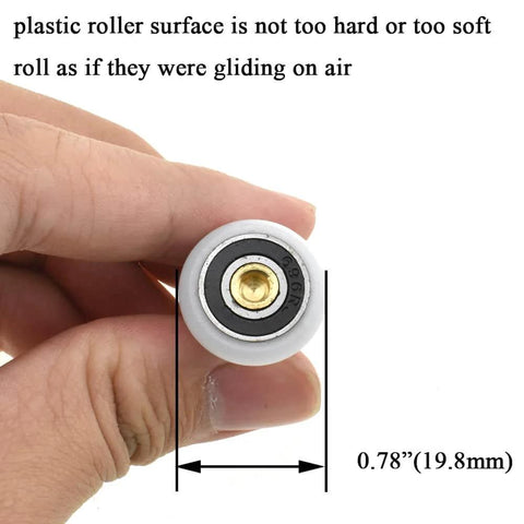 Close-up of 20mm diameter brass shower door wheel with nylon roller and ball bearing, held in hand.