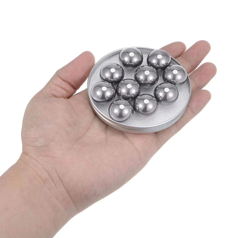 Hand holding a set of 20pcs 20mm Carbon Steel Bearing Balls Precision Polished on a round plate