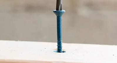 Close-up of 1/4 Inch Hex Washer Head Concrete Screw For Masonry, Brick And Block, Self Drilling Tapcon Style Anchor in concrete