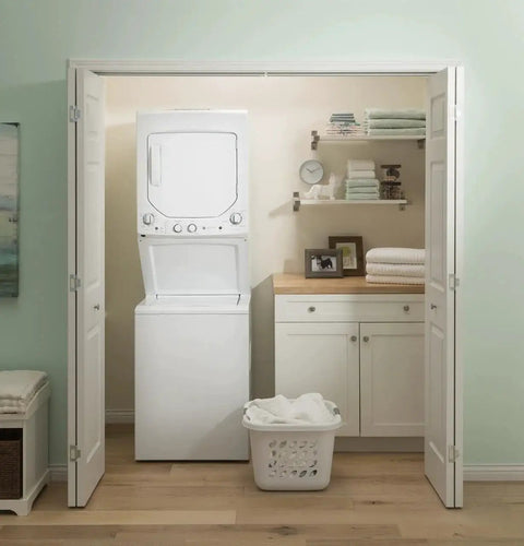 Compact 27 inch unitized washer and electric dryer in one space-saving cabinet in a laundry closet setup.