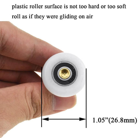 Close-up of 27mm diameter brass shower door wheels with nylon rollers and ball bearings, held in hand for size comparison.