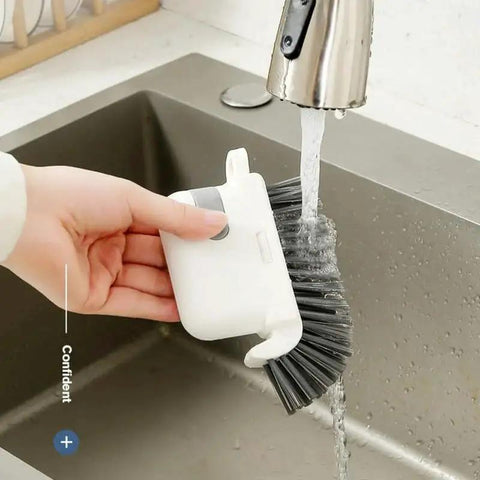 Person rinsing 3-In-1 Removable Window Slot Brush With Hidden Scraper under faucet, showcasing cleaning tool use in kitchen sink.