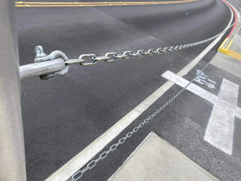 3/16-IN X 10-FT Heavy Duty Proof Coil Chain, Bright Zinc-Plated Metal Chain, installed outdoors along a curved road