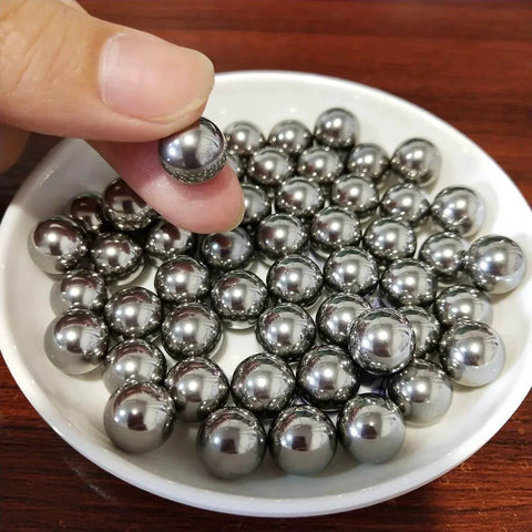 Hand holding 0.3mm solid 316L stainless steel ball over a dish of 100Pcs 0.3mm Solid 316L Stainless Steel Ball - Smooth Beads Round Balls.