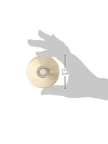 Hand holding lit stucco pushbutton doorbell button with gold rim pearl button 5/8 inch diameter and 2-1/2 inch gold anodized plate