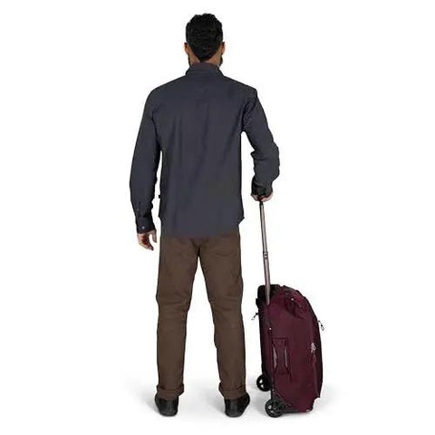 Person holding Ozone 2-Wheel Carry-On Luggage With Oversized Wheels And Telescoping Handle From Osprey, rear view