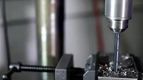 Close-up of 1/8 In NPT Pipe Tap And R HSS Drill Bit Set In Carbon Steel, Black Oxide Finish, drilling metal in a maintenance jobsite scene.