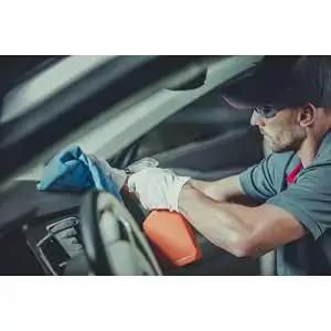 Person using Blue 14x14 Inch 100-Pack Cotton Auto Shop Towels For Detailing And Industrial Cleaning on car interior dashboard.
