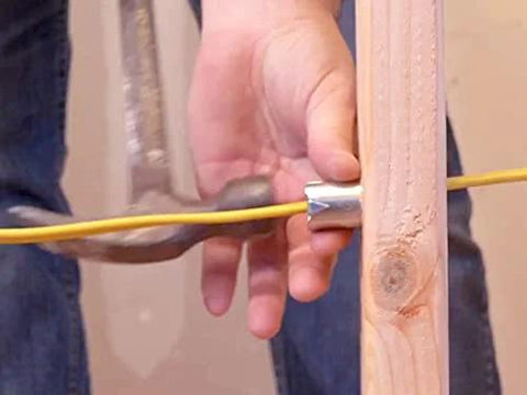 Southwire Smart Shield wire protection guard being installed on a wooden stud to shield an electrical cable.