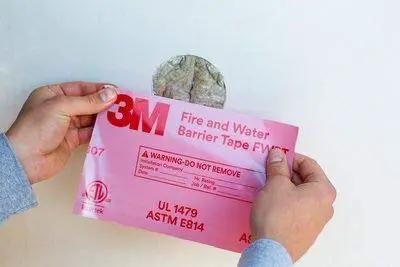 Applying Fire and Water Barrier Tape FWBT4 4 in x 75 ft to wall penetration for firestop seal