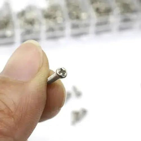 Close-up of a stainless steel silver micro screw from the Stainless Steel Silver Micro Screws Set for Glasses and Watches, Metric Tiny Screws M1.2 M1.4 M2.0, held between fingers.