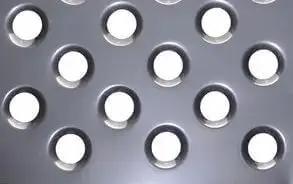 Close-up of metal sheet with dimples created by Six Piece Dimple Die Set Half Inch Through One And Three Quarter Inch Sizes, Heavy Duty SAE 8620 Steel.