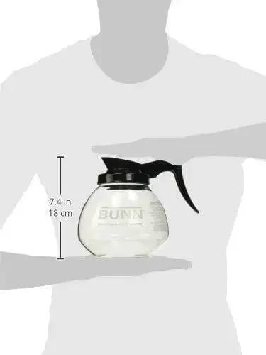 Person holding shatter-resistant glass carafe from Coffee Pot Decanter Carafe Set With 12 Cup Capacity, Three Pieces Including Two Black Regular And One Orange Decaf, Shatter Resistant Laboratory Grade Glass, Durable Easy Pour For Home Kitchen And Office Coffee Bar.