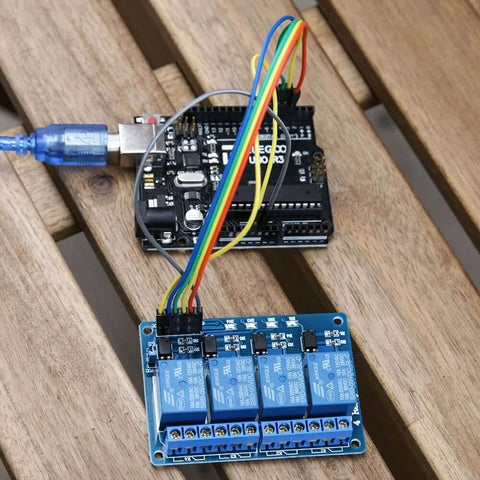 4 Channel 5V Relay Module With Optocoupler for Arduino setup with cables connected on a wooden table