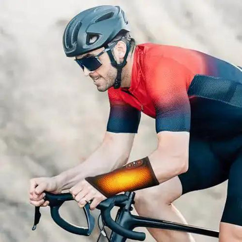 Cyclist wearing wrist heating pad for pain relief, featuring Cordless Wrist Hand Heating Pad Massage For Carpal Tunnel Relief With 3000mAh Battery And Vibration.