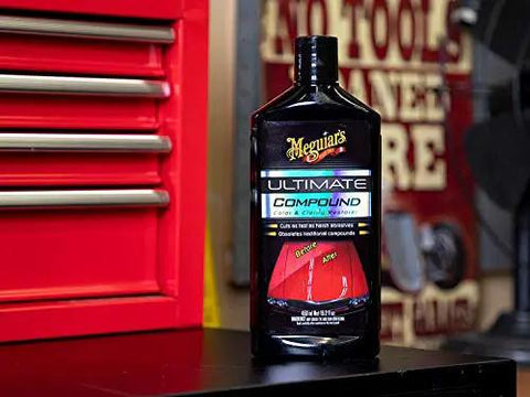 Ultimate Compound Pro Grade Car Scratch Remover For Killer Shine And Glossy Paint Finish Defect Removal Paint Correction Compound For Single Stage And Clear Coat 15.2 Oz bottle on a workbench.