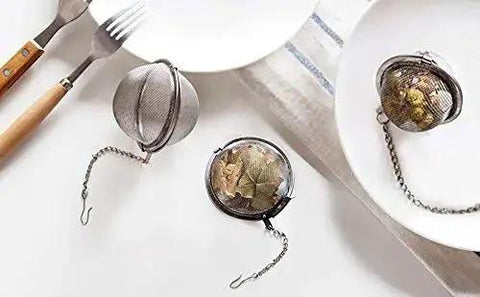Two Pack 2.1 Inch Stainless Steel Mesh Tea Ball Infuser Strainer Filters For Teas Durable 304 Grade Tea Filter Basket on a dining table