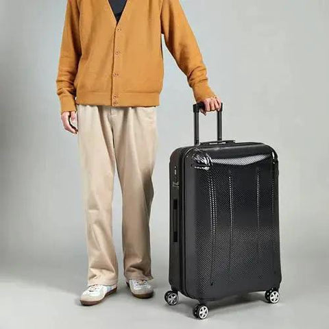 Person holding 30 Inch Hardside Spinner Luggage With TSA Lock, Lightweight Expandable Suitcase, Scratch-Resistant Exterior, 97 Liter Capacity, Eight 360-Degree Wheels For Effortless Rolling, Black Amazon Basics.