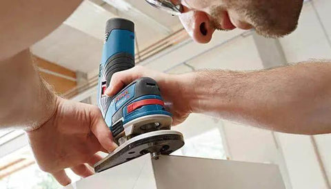 Person using Bosch router with 15 Piece Micrograin Carbide Tipped Wood Router Bit Set Universally Compatible For DIYers on wood