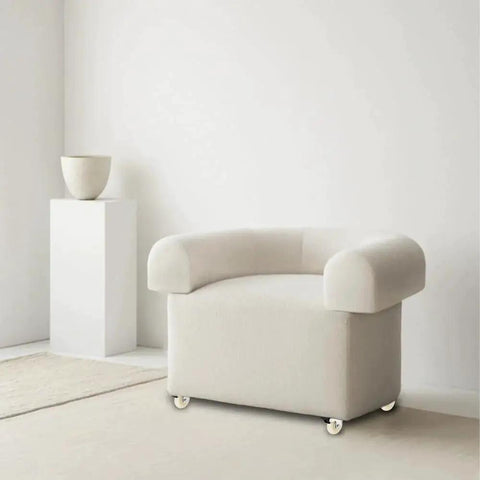 Modern beige armchair on casters in minimalist room with white decor