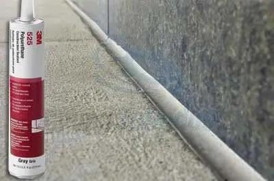 Polyurethane Construction Sealant 525 Gray 10.5 oz cartridge sealing a concrete joint; shown with the product in use on stone surface.