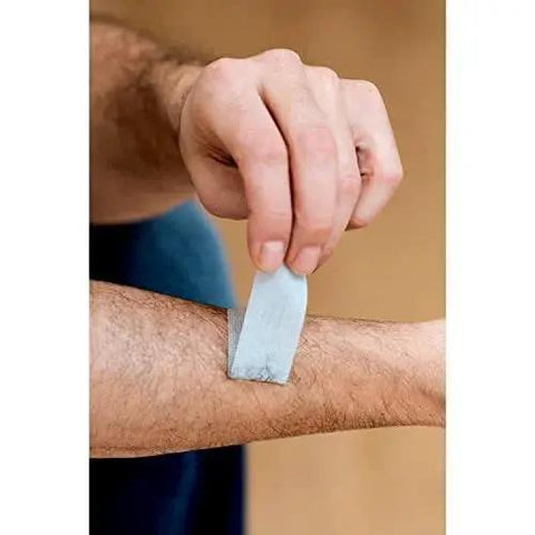 Person applying Strong Hold Pain Free Tape For Sensitive Skin 1 Roll 1 In X 4 Yds Silicone on forearm, showing painless removal.