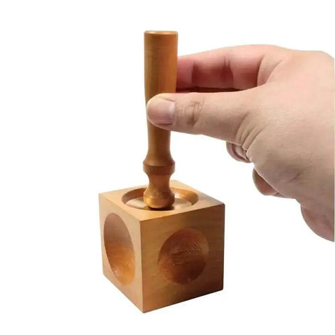 Hand holding a punch tool on a Wooden Square Dapping Block Punch Kit for DIY Doming and Stamping of Soft Metals Like Gold Silver Copper Aluminum