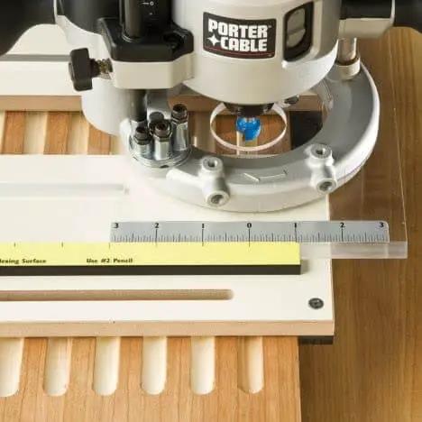 Router Fluting Jig For Perfect Flutes Pro Grade Setup With Easy Custom Drilling For Non Standard Profiles Ideal For Columns Molding And Furniture Parts Built From MDF And Aluminum With Stable Table Top For Fast Repetitive Routing, shown installed on wood with acrylic centerpiece and ruler.
