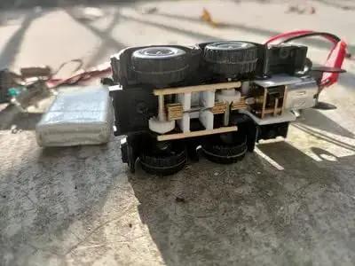 12V DC Mini Gear Motor N20 with D Shaft, fixed frame, plastic wheels shown in a DIY toy project setup for robotics.