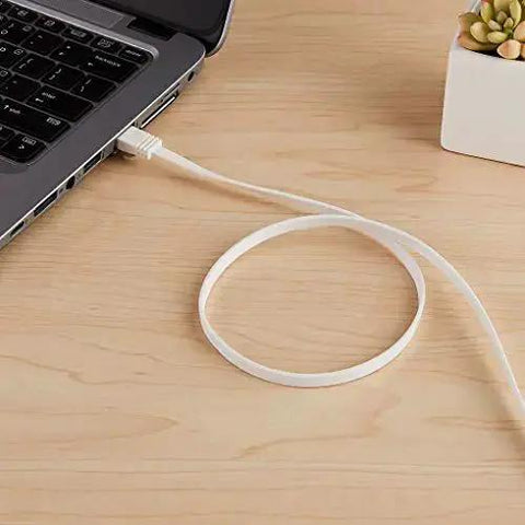Flat Cat6 Ethernet Cable 100Ft Snagless Patch Cord With Gold Plated Connectors connected to a laptop on a wooden desk surface.