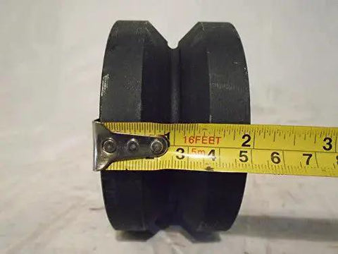 Rigid Caster With 7/8 Inch V-Groove Iron Steel Wheel, close-up view with tape measure for scale.