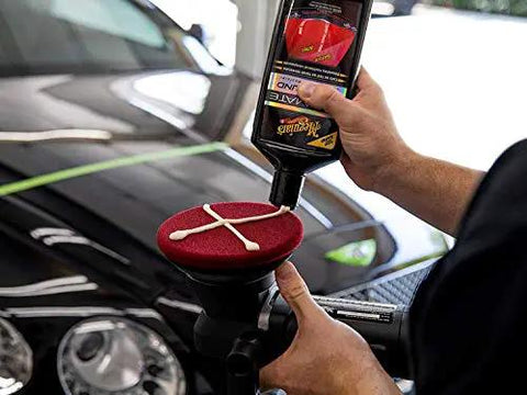 Ultimate Compound Pro Grade Car Scratch Remover For Killer Shine And Glossy Paint Finish Defect Removal Paint Correction Compound For Single Stage And Clear Coat 15.2 Oz applied to foam pad on polisher.