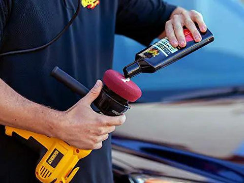Person using Ultimate Compound Pro Grade Car Scratch Remover For Killer Shine And Glossy Paint Finish with a polishing tool.