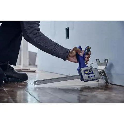 Person using Quick Lift Construction Jack With 10 Inch Lift And 330 Lb Capacity to level flooring in a home workshop.