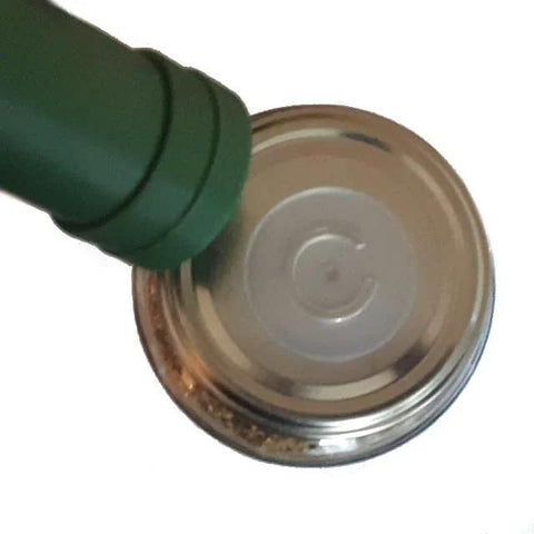 aPraktika vacuum valve for food storage, green plastic valve on a silver metal jar lid.