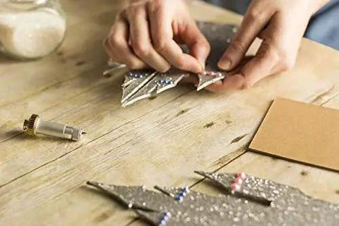Person crafting with knife blade and drive housing for makers compatible with Cricut Maker cutting machine on a wooden table.