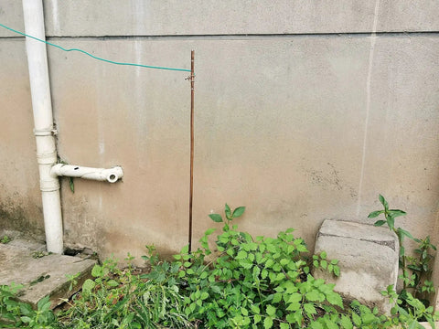 4 Foot Ground Rod With 15 Foot 12 AWG Tinned Copper Ground Wire UL Listed for outdoor setup near wall and greenery