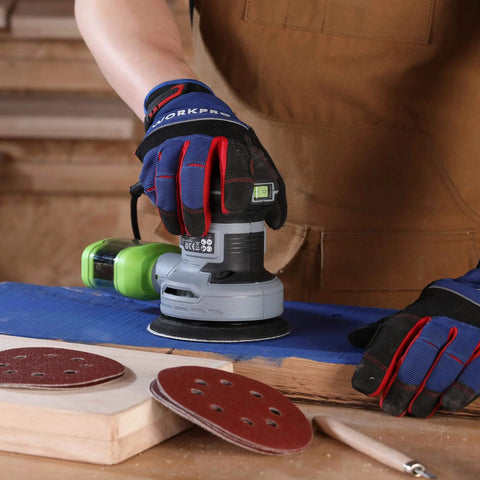 Hand using random orbital sander with 150 piece sanding discs set 5 inch 8 hole grits 60 to 600 on wood surface