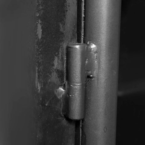 Close-up of black 5-inch heavy-duty weld-on barrel hinge for metal gate, showing greaseable zerk and ball bearings installed on surface.