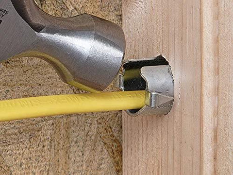 Southwire Smart Shield nail guard around a yellow electrical cable in a wall stud, hammer nearby.