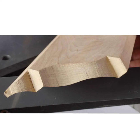 Close-up of a wooden molding with curved edges, showing clean cope cuts made by Speed Cope Crown Molding Jig With Adjustable Handle For DIY Woodworking.