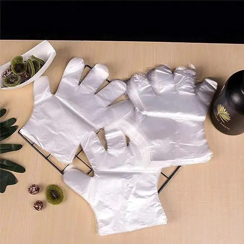 Clear Plastic Disposable Gloves For Food Prep And Service Bulk 6000 Pcs displayed on a kitchen counter with kiwis and a bottle.
