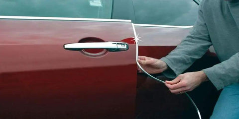 Person installing Enhanced 18ft Chrome U Channel Edge Guard Trim For Door Edges And Bumpers on a car door.