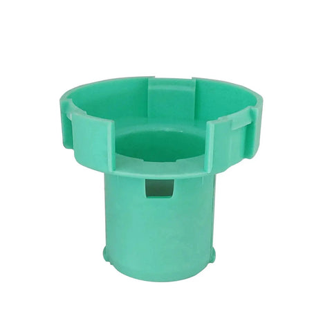 Close-up of a green plastic component, possibly part of a steering mechanism, with a cylindrical shape and ridged design edges.