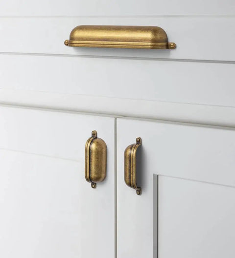 Antique Brass Zinc Alloy Cup Drawer Pulls Set of 6 For Kitchen Cabinets and Drawers, installed on white cabinets