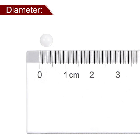 Ceramic bearing ball, 5mm diameter, white zirconia (ZrO2) precision ball beside ruler.