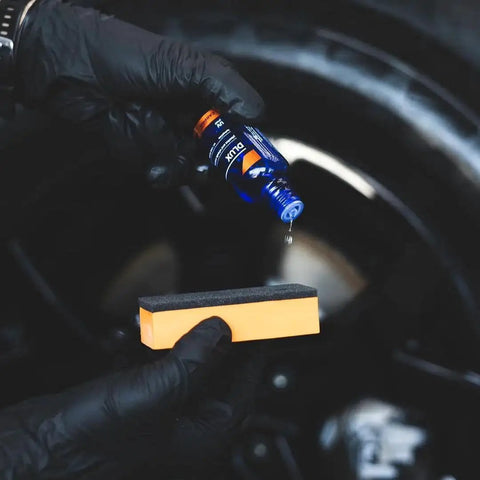 Hands applying DLUX Wheel and Trim Ceramic Coating 30mL With UV Protection for Alloy Wheels, Exterior Plastics
