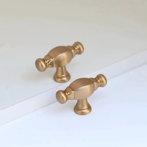 Two modern champagne bronze zinc alloy cabinet knobs on white surface, 10 Pack Champagne Bronze Bar Cabinet Knobs Zinc Alloy Furniture Drawer Pulls.
